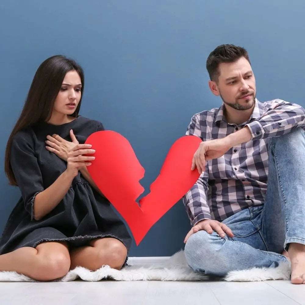 Pareja sentada con un corazón roto de papel — sesión de tarot terapéutico de 30 minutos | Tarot Kenna