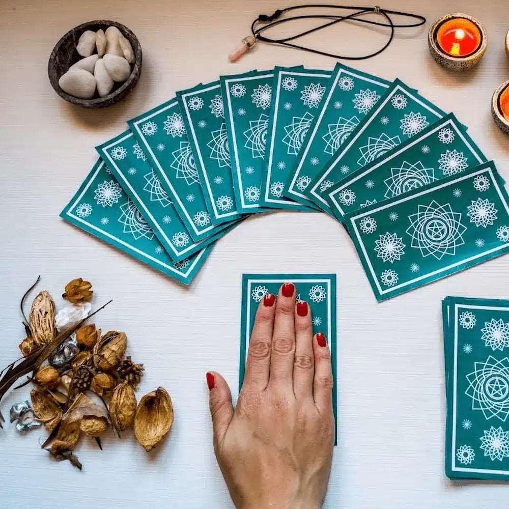 Mano sobre cartas de tarot — sesión de 45 minutos por teléfono o WhatsApp | Tarot Kenna